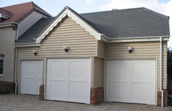 Triple garage in Greenfield, Bedfordshire with Cotswold Moreton up and over doors in white